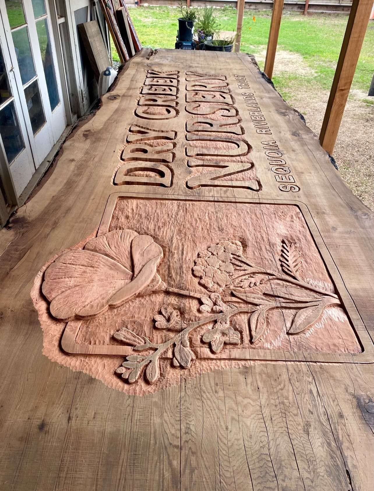 Dry Creek Nursery carved redwood slab sign with raised lettering and botanical relief