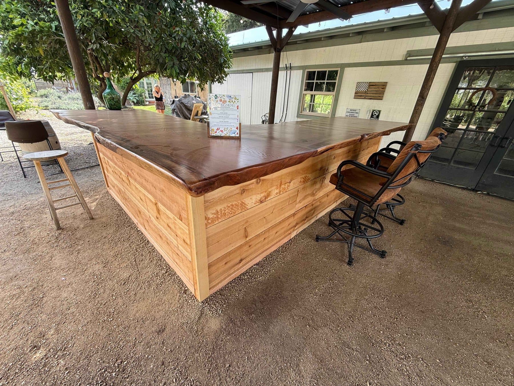 Finished live-edge redwood slab bar in an outdoor tasting area at 3 Oaks Winery