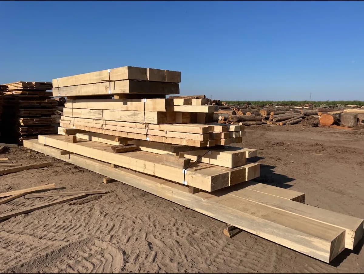 Stacks of dimensional rough-sawn lumber in an outdoor lumber yard
